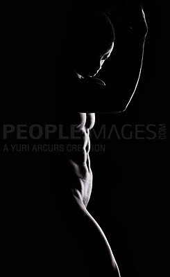 Buy stock photo Artistic shot of a muscular young man posing in studio against a dark background