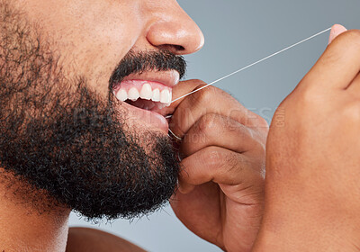 Buy stock photo Oral care, floss and mouth of man in studio for gum, protection and plaque removal. Male person, teeth and thread in hands for cleaning, hygiene and dental wellness on gray background in morning