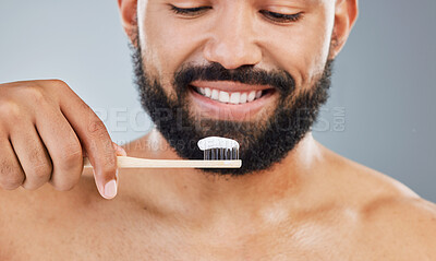 Buy stock photo Man, toothpaste and toothbrush in studio for dental care, plaque removal and fresh breath for mouth. Person, gray background and oral hygiene for wellness routine and white smile or gum health.