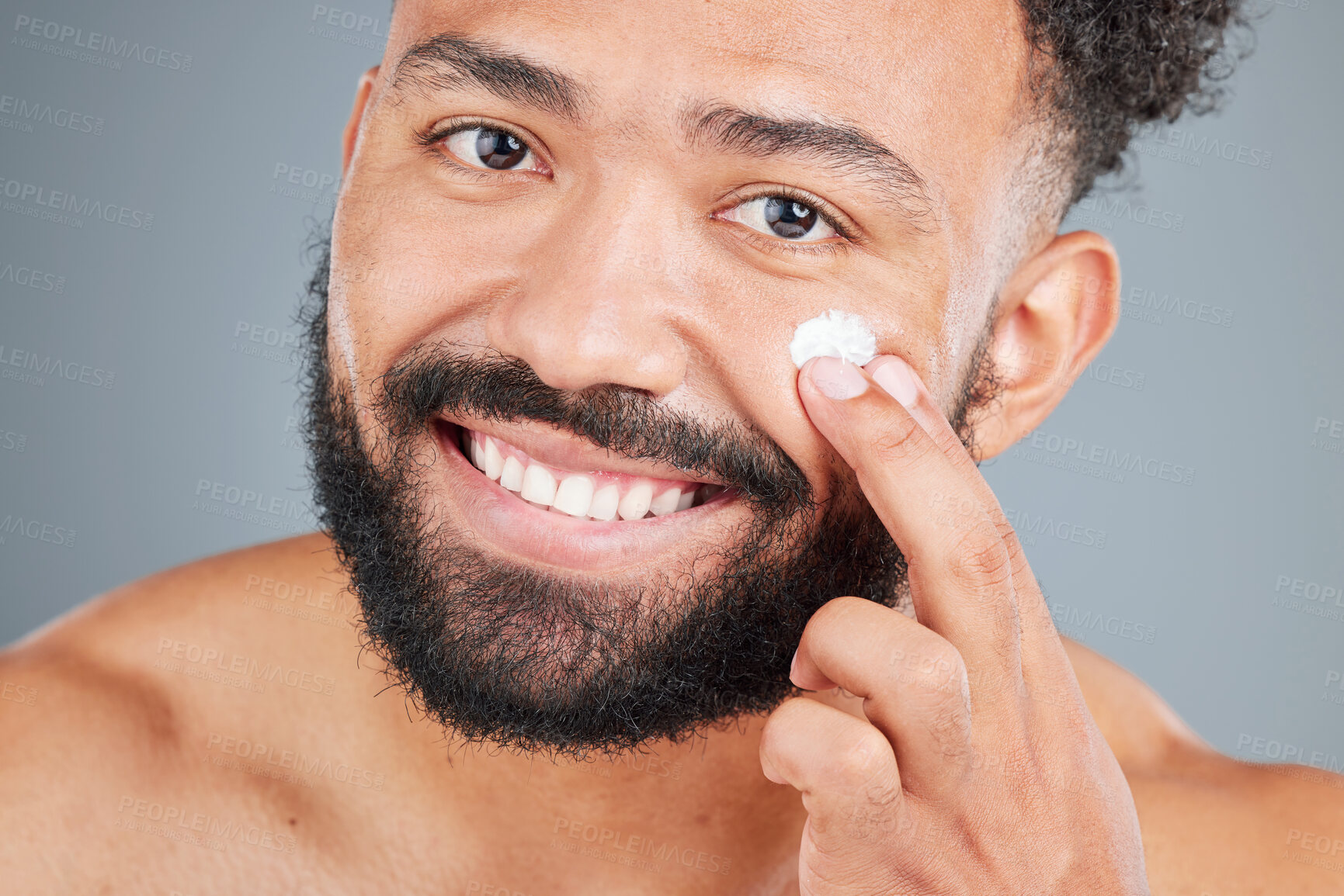 Buy stock photo Smile, cream and portrait of man in studio for skincare, facial treatment and skin tone or hydration. Male person, lotion and sunscreen for uv protection on gray background, closeup and grooming.