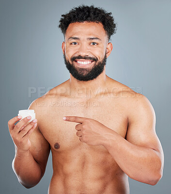 Buy stock photo Portrait, happy man and pointing in studio for cream, dermatology and pride for grooming. Male model, wellness and shine or glow for facial treatment or routine in morning with spf by gray background