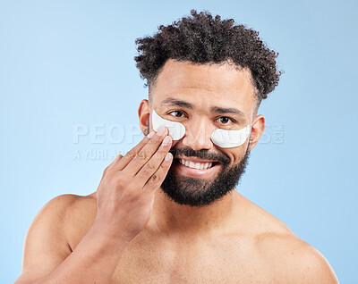 Buy stock photo Man, eye and patch with portrait in studio for skincare, facial treatment and cosmetic product for dark circles or grooming. Male person, happy and blue background for anti aging and skin tone.