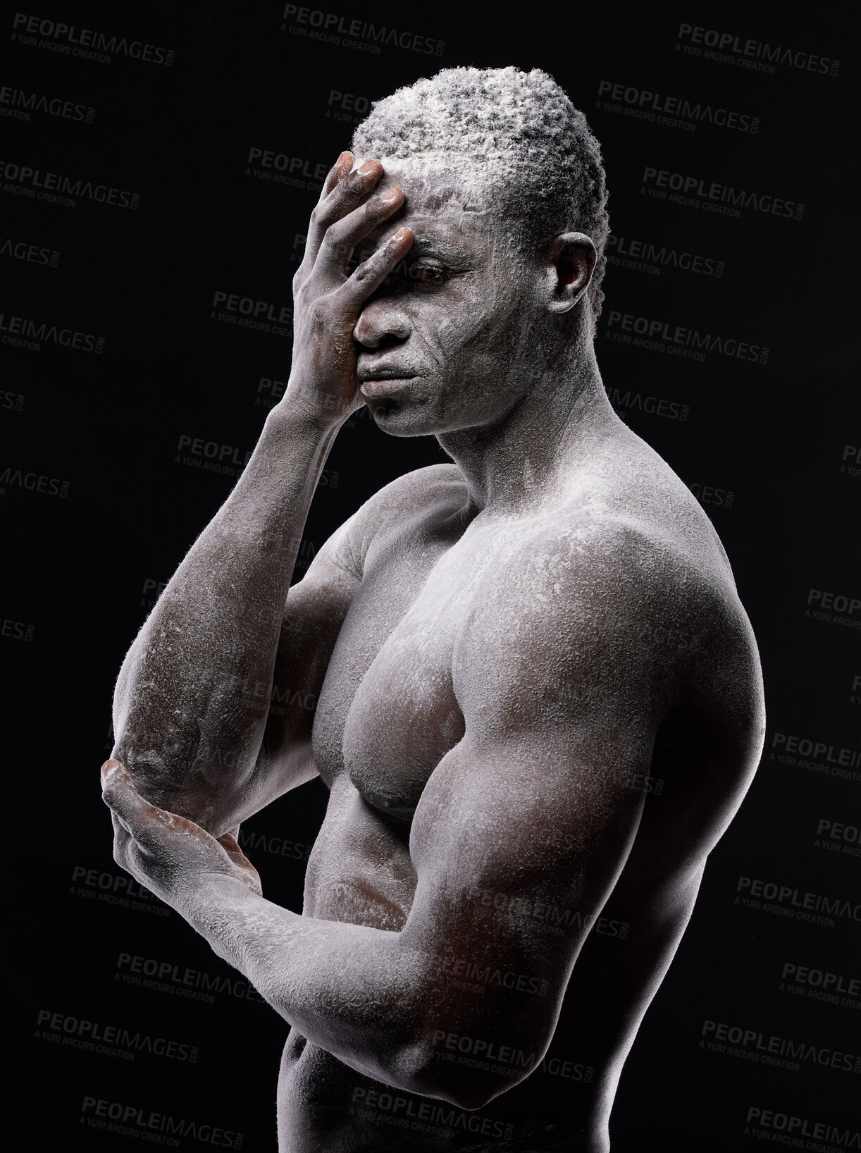 Buy stock photo Artistic shot of a muscular young man posing with white powder in studio against a dark background