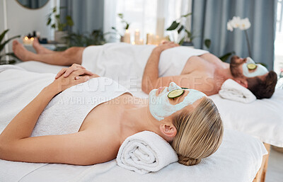 Buy stock photo Shot of a young couple wearing cucumbers on their eyes in a spa