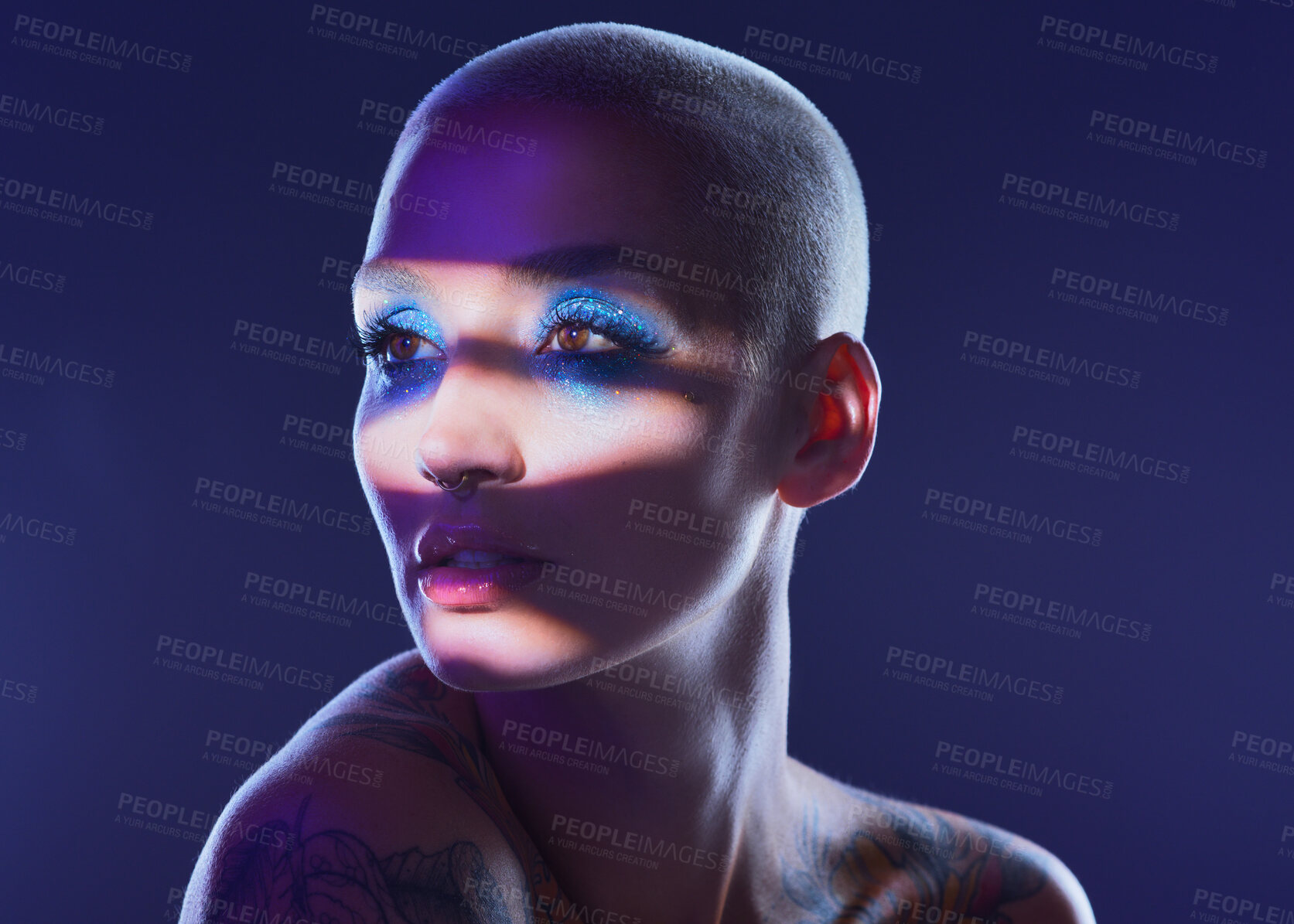 Buy stock photo Studio shot of an attractive young woman wearing edgy makeup against a blue background