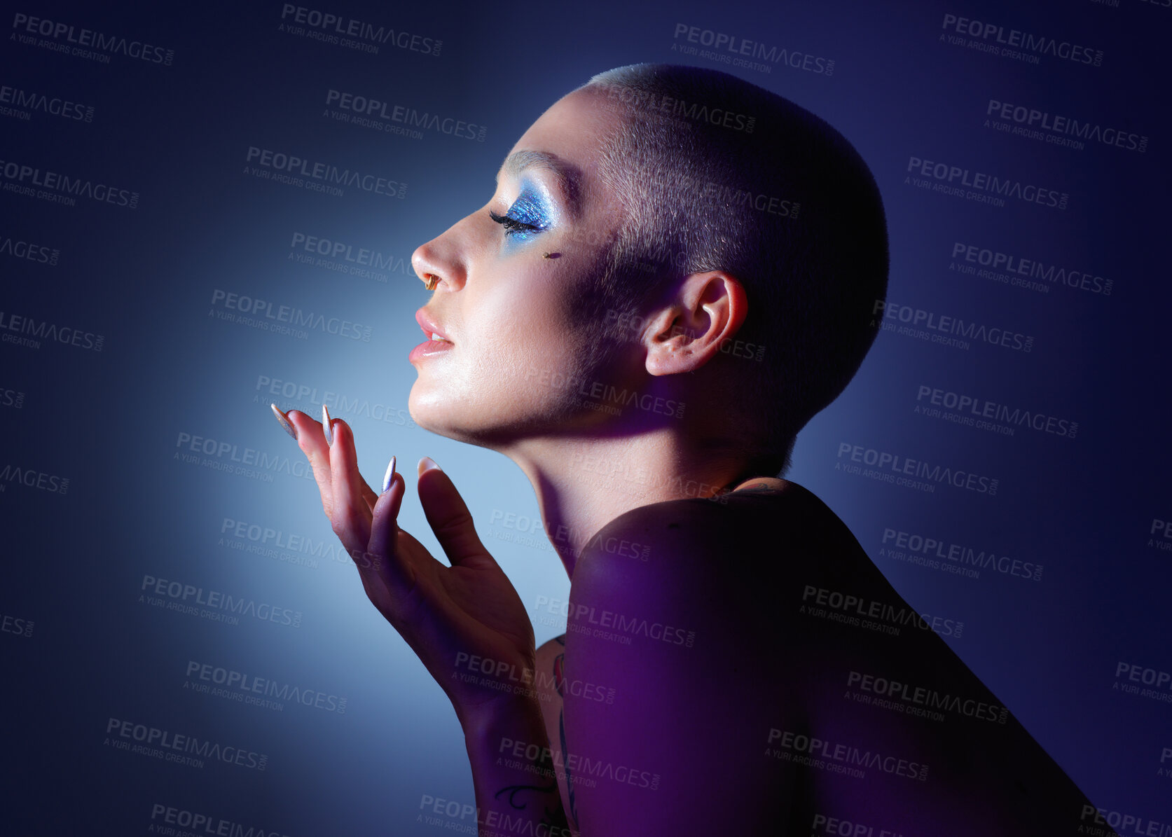 Buy stock photo Studio shot of an attractive young woman wearing edgy makeup against a blue background