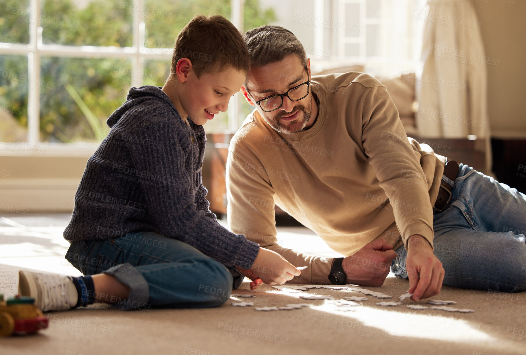 Buy stock photo Father, child and relax with puzzle at house for problem solving, learning and connect pieces of education. Smile, family and jigsaw with creative development, bonding together and childhood support