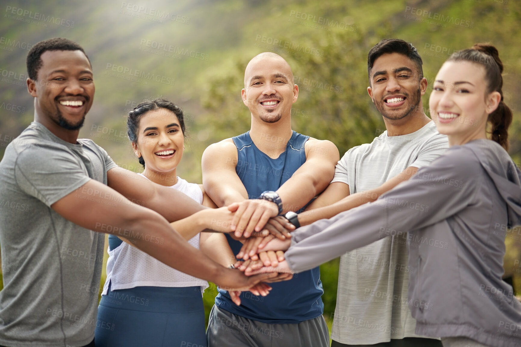 Buy stock photo Portrait of a group of sporty young people joining their hands together in a huddle