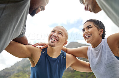 Buy stock photo Shot of a group of sporty young people standing together in a huddle while exercising outdoors