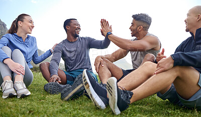 Buy stock photo Shot of a group of sporty young people giving each other a high five while taking a break from exercising outdoors