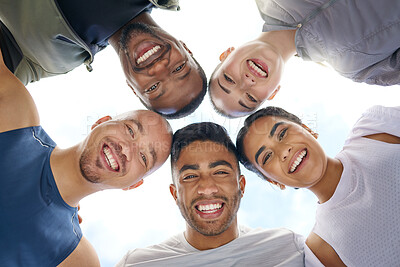 Buy stock photo Low angle shot of a group of sporty young people joining their heads together in a huddle outdoors