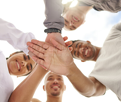 Buy stock photo Low angle shot of a group of sporty young people joining their hands together in a huddle