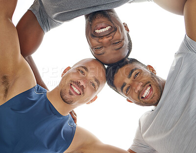 Buy stock photo Low angle shot of a group of sporty young people joining their heads together in a huddle outdoors