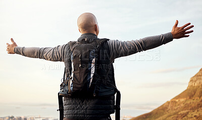 Buy stock photo Rearview shot of an unrecognizable young man enjoying the view during his hike in the mountains