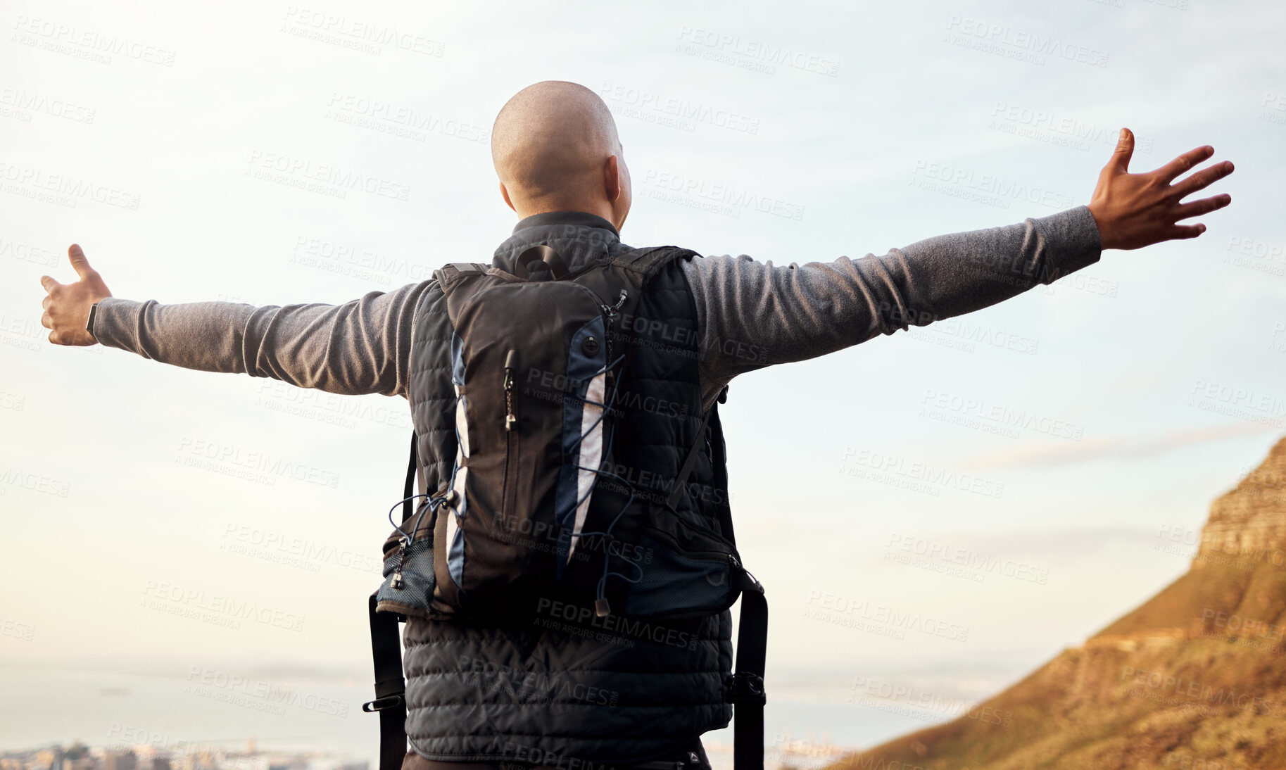 Buy stock photo Rearview shot of an unrecognizable young man enjoying the view during his hike in the mountains