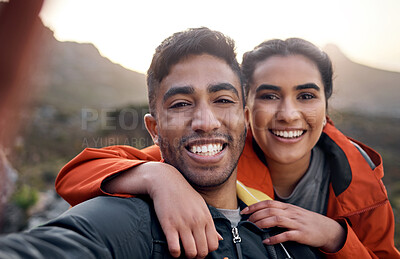 Buy stock photo Cropped portrait of an affectionate young couple taking selfies while hiking in the mountains