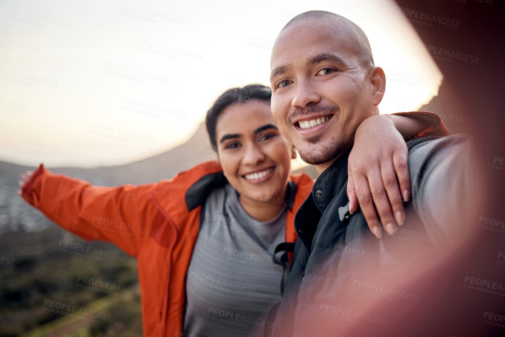 Buy stock photo Cropped portrait of an affectionate young couple taking selfies while hiking in the mountains