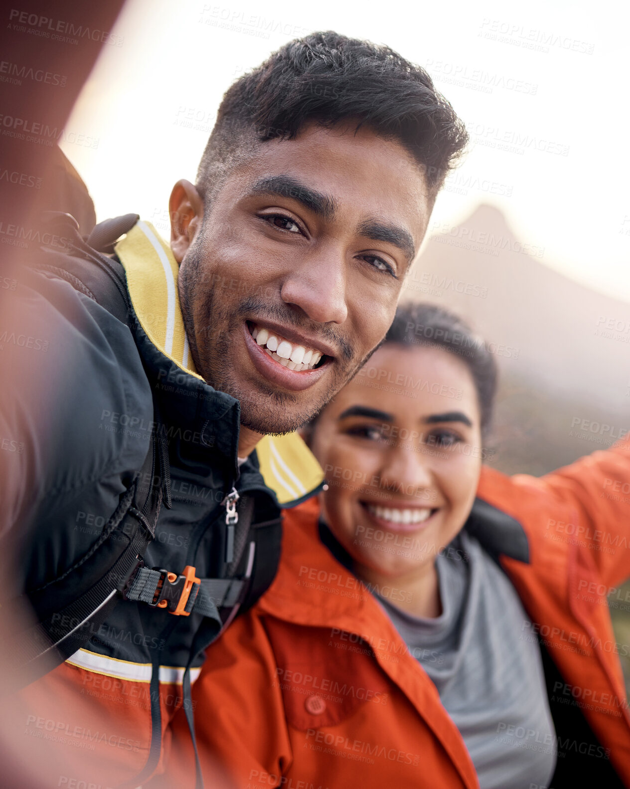 Buy stock photo Cropped portrait of an affectionate young couple taking selfies while hiking in the mountains