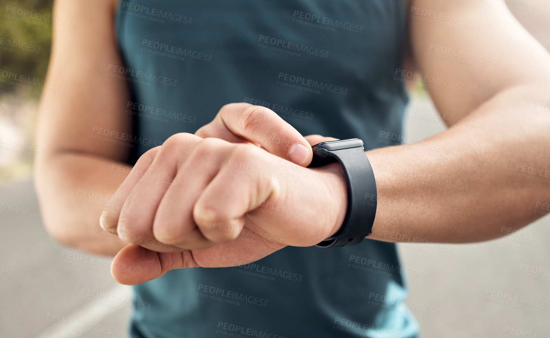 Buy stock photo Shot of a man checking his watch while out for a run