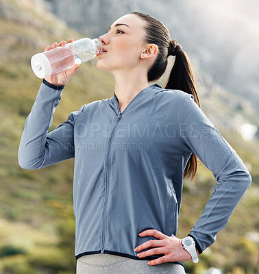 Buy stock photo Shot of a woman drinking water while out for a workout
