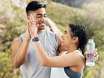 Buy stock photo Shot of a couple giving each other a high five while out for run
