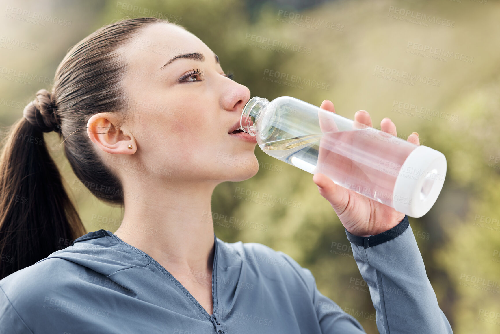 Buy stock photo Shot of a woman drinking water while out for a workout