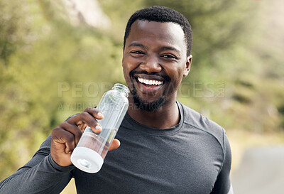 Buy stock photo Shot of a man drinking water while out for a workout