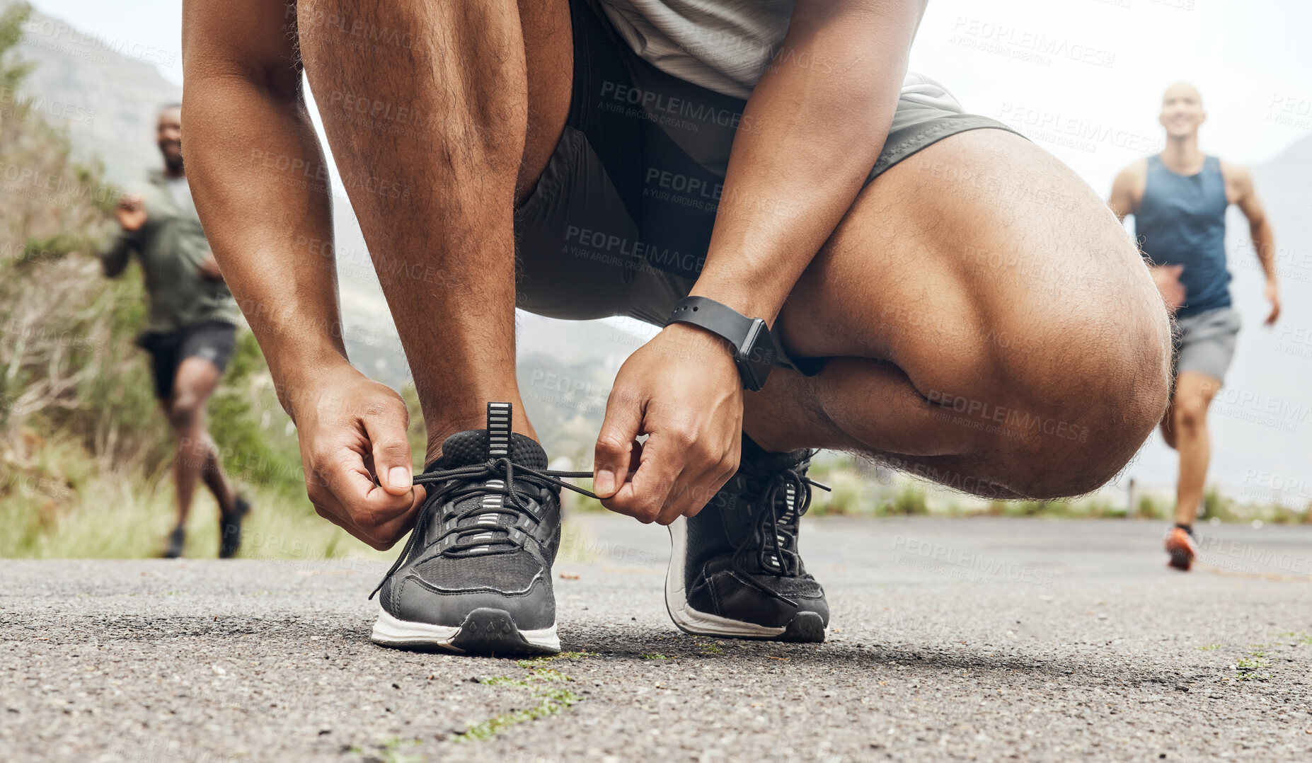 Buy stock photo Shot of an athletic man tying his laces while our for a run