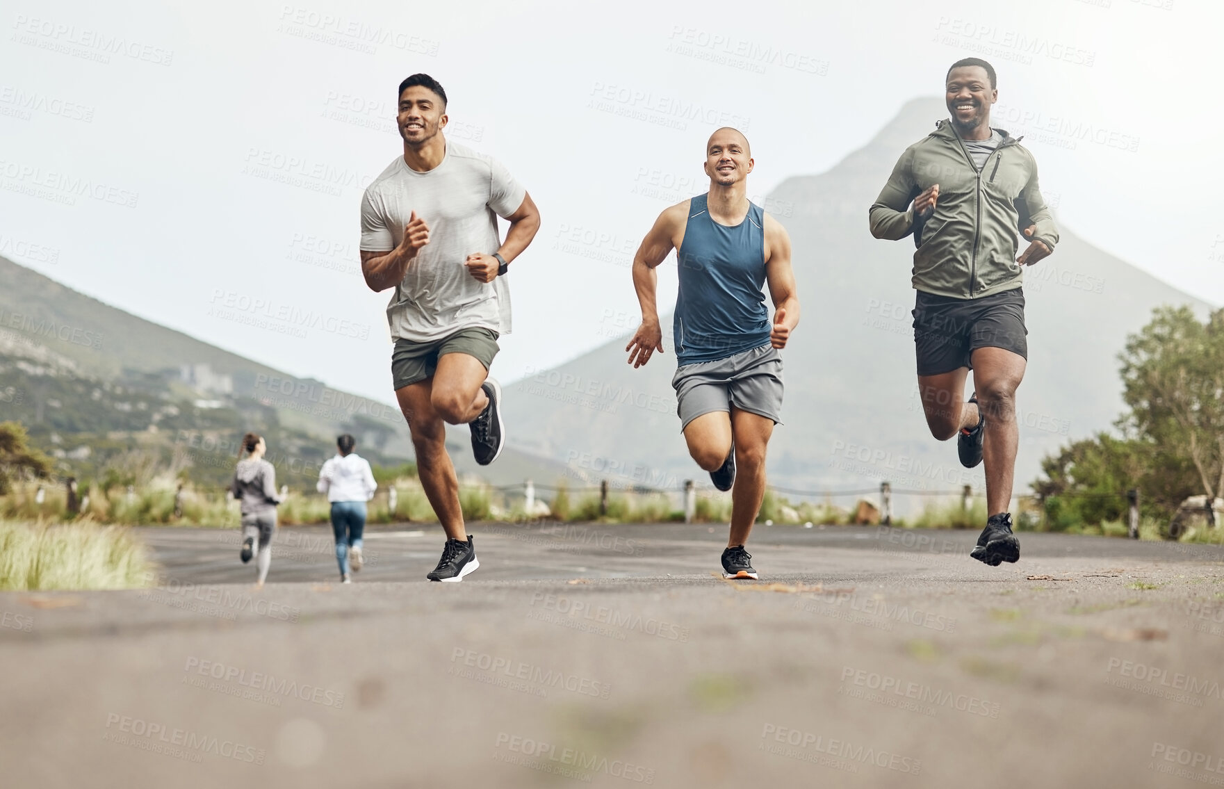 Buy stock photo Shot of three men out for a run on a mountain road