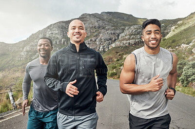 Buy stock photo Shot of three men out for a run on a mountain road
