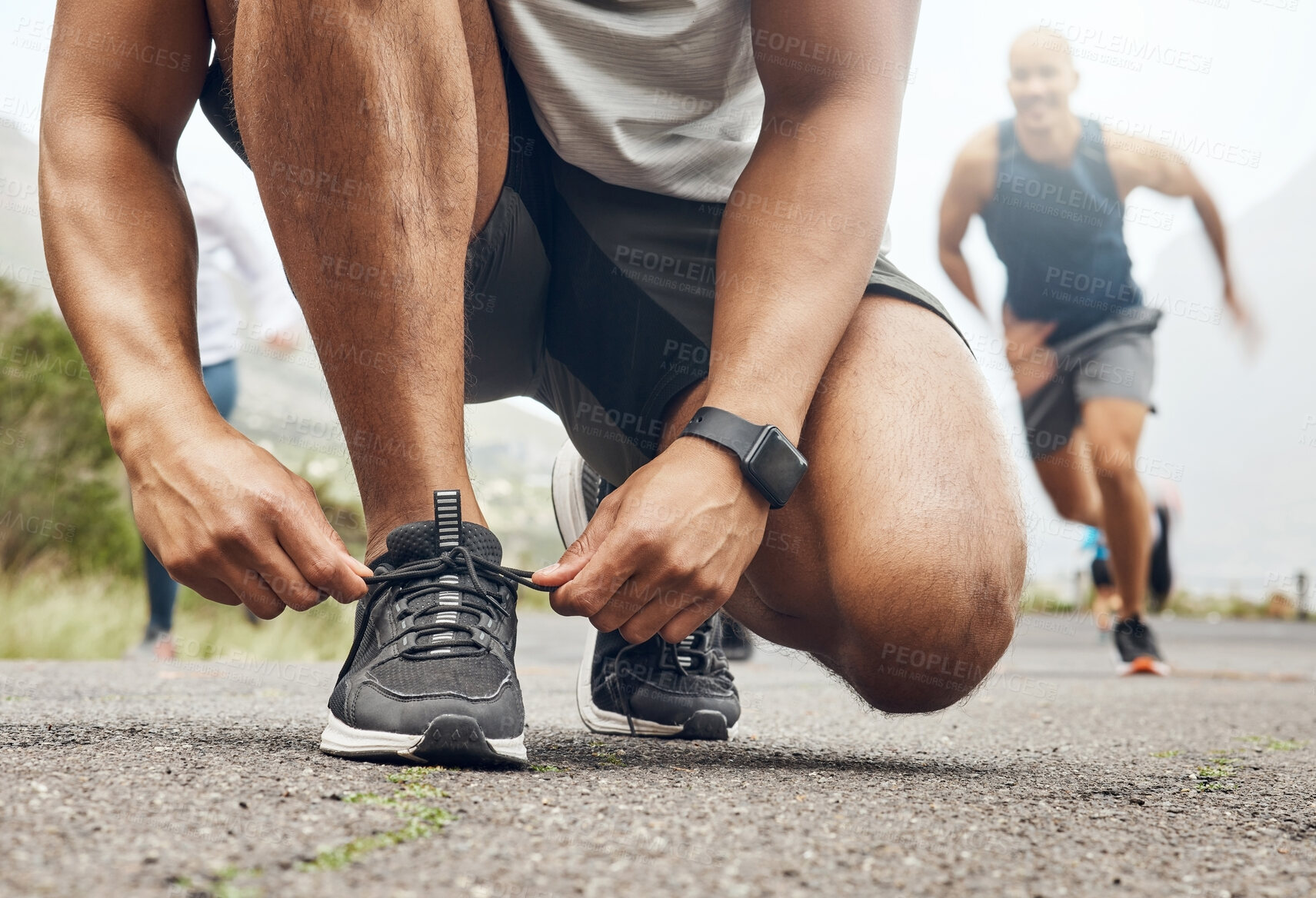 Buy stock photo Shot of an athletic man tying his laces while our for a run