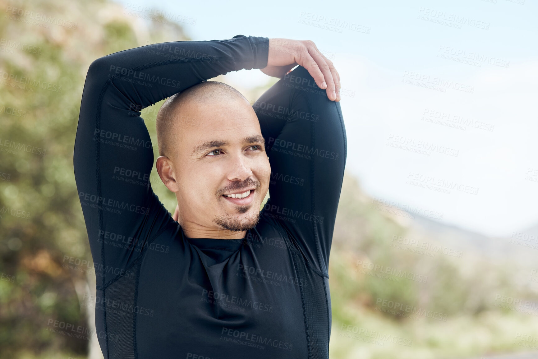 Buy stock photo Shot of an athletic young man stretching outside