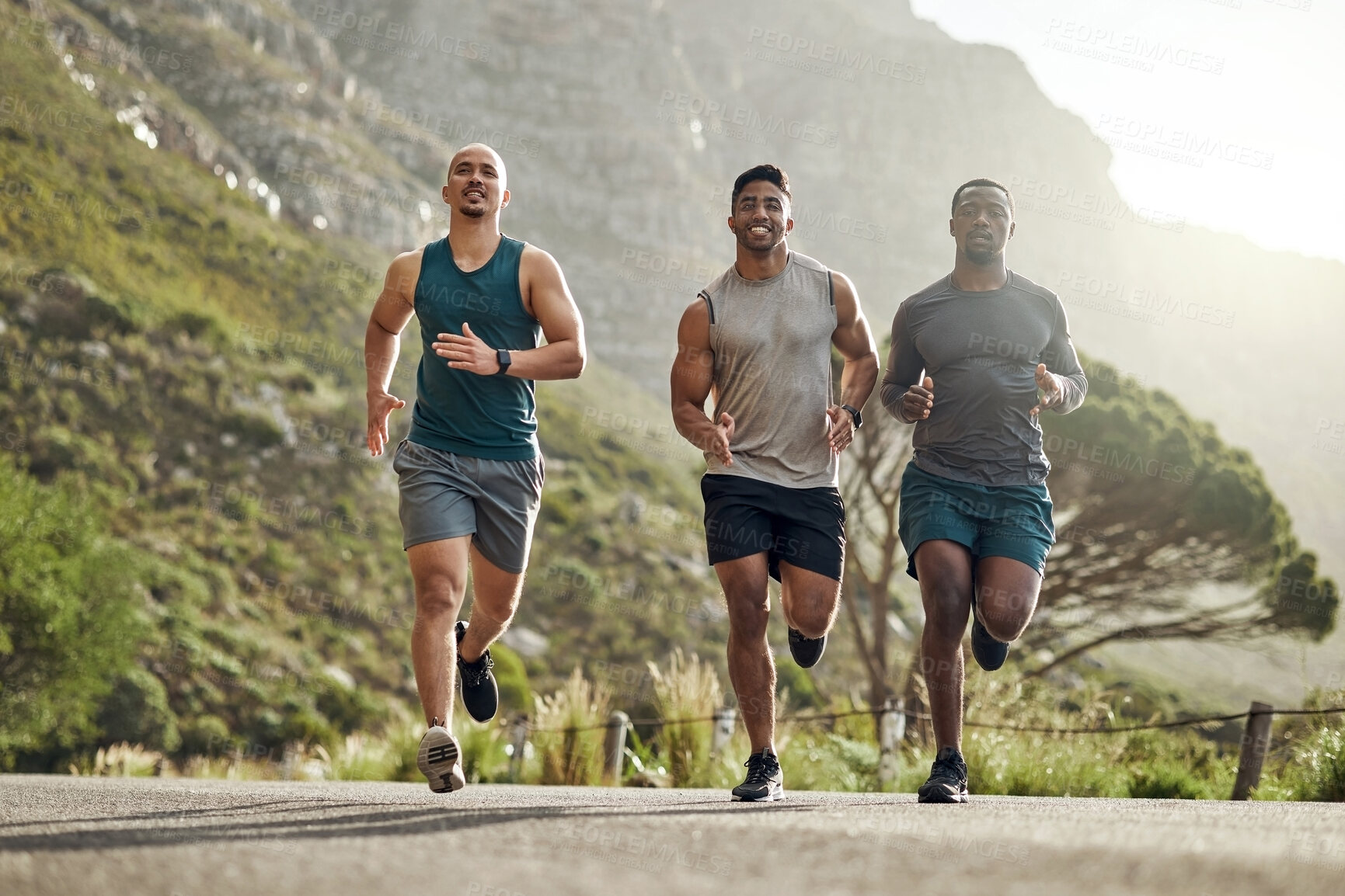 Buy stock photo Shot of three men out for a run on a mountain road