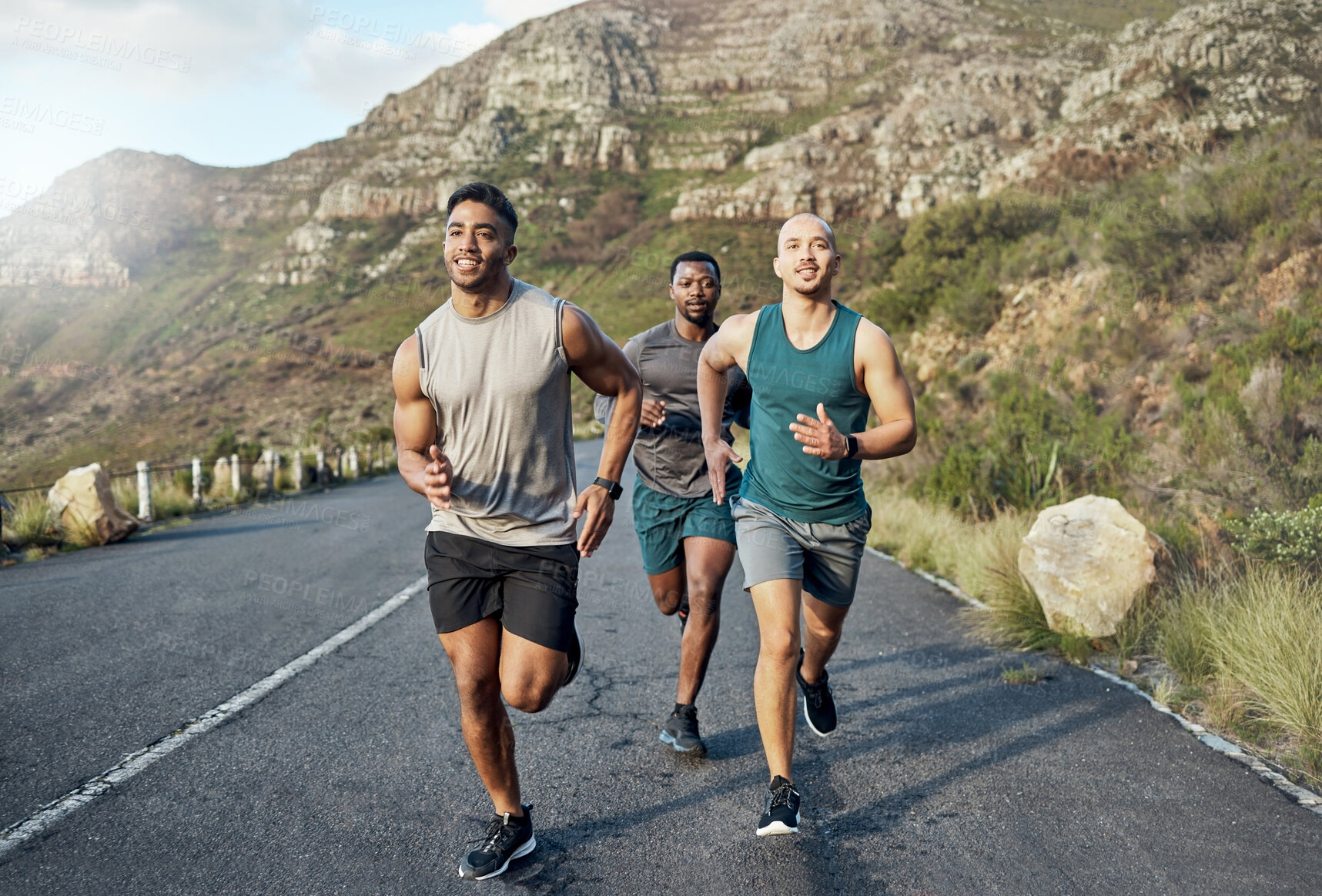 Buy stock photo Shot of three men out for a run on a mountain road