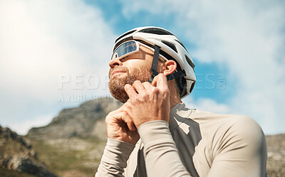 Buy stock photo Cropped shot of a handsome mature man fastening his helmet while cycling outdoors