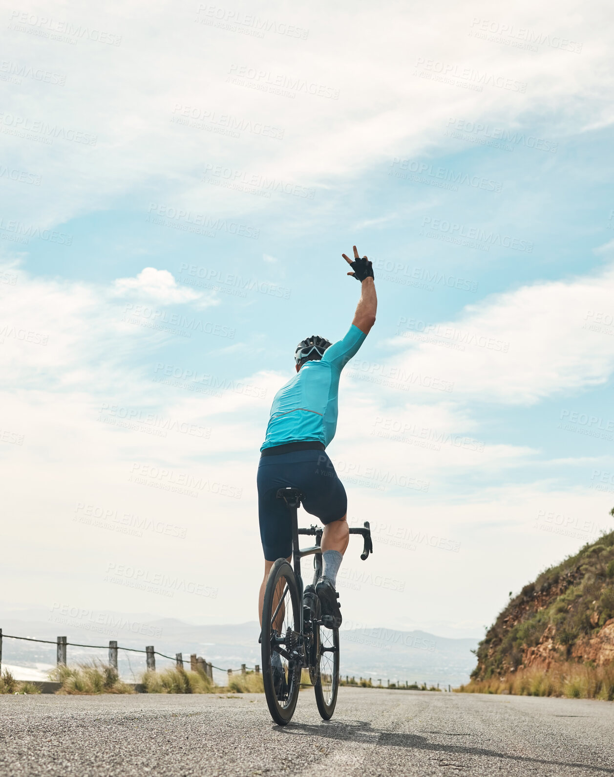 Buy stock photo Rearview shot of an unrecognizable man gesturing goodbye while cycling outdoors