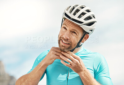 Buy stock photo Cropped shot of a handsome mature man fastening his helmet while cycling outdoors