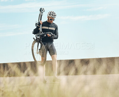 Buy stock photo Full length shot of a handsome mature man carrying his bike while cycling outdoors