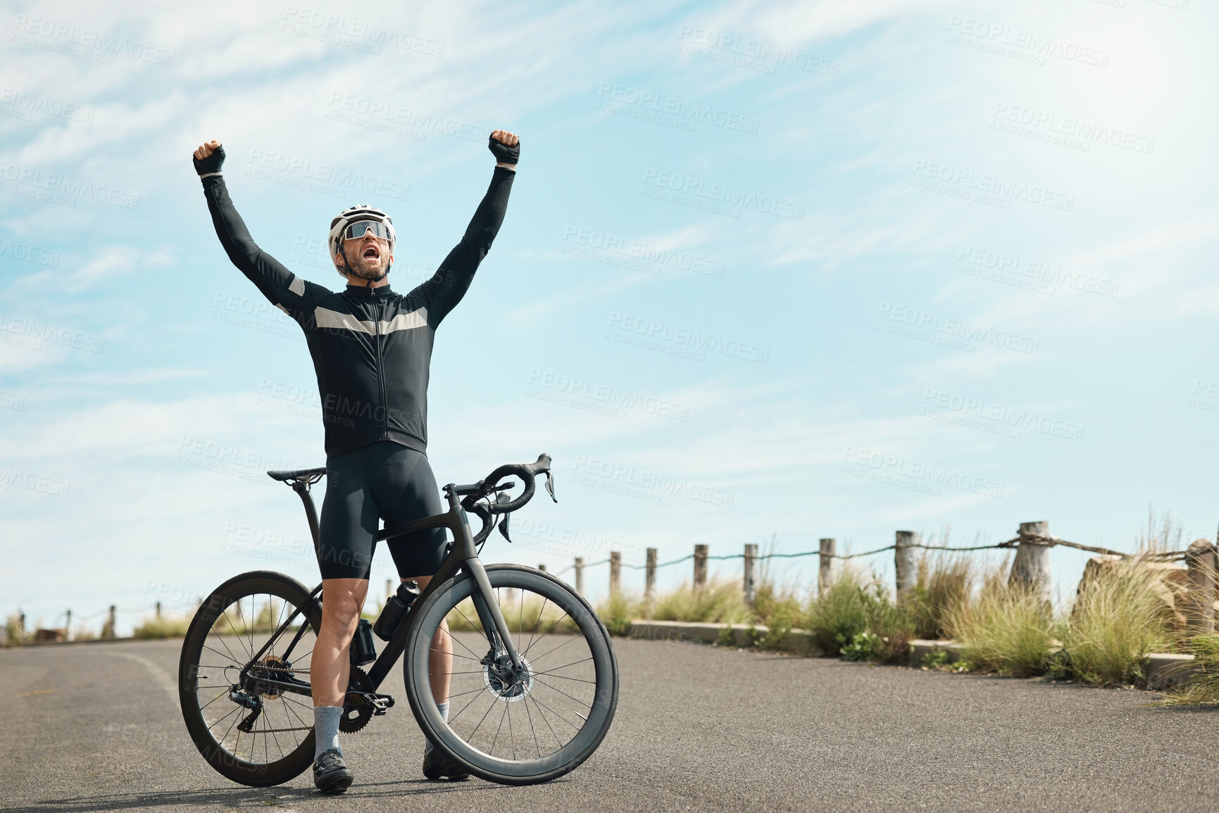 Buy stock photo Full length shot of a handsome mature man standing with his arms raised in celebration while cycling outdoors