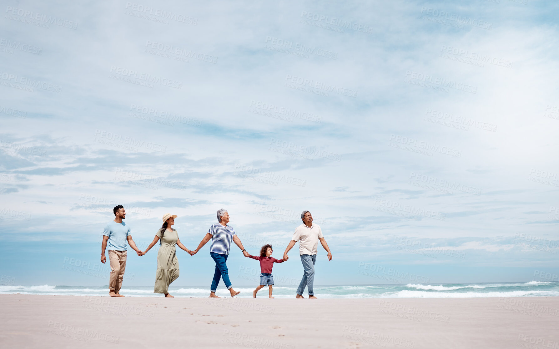 Buy stock photo Shot of a multi-generational family spending the day at the beach