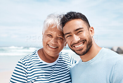 Buy stock photo Shot of a young man spending the day at the beach with his elderly mother