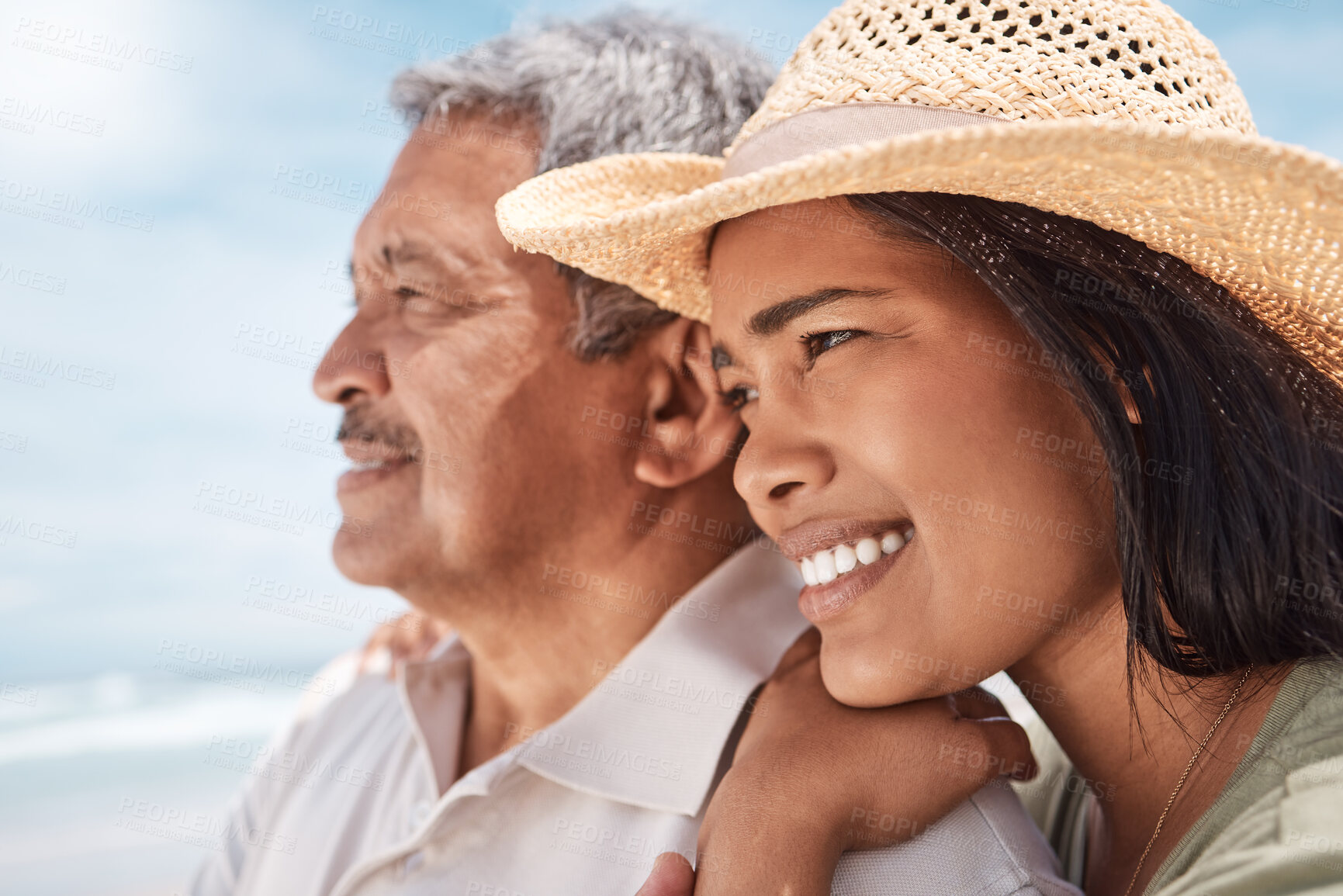 Buy stock photo Shot of a young woman spending the day at the beach with her elderly father