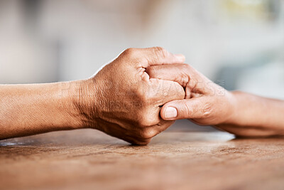 Buy stock photo Shot of an unrecognizable senior couple holding hands and comforting one another at home