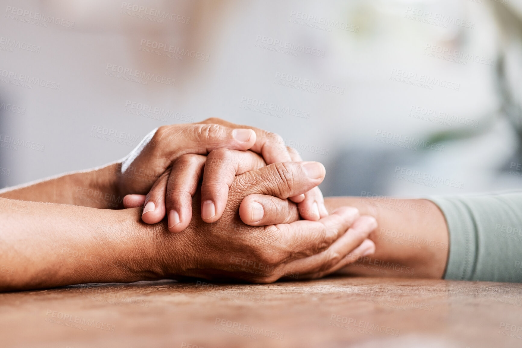 Buy stock photo Shot of an unrecognizable senior couple holding hands and comforting one another at home