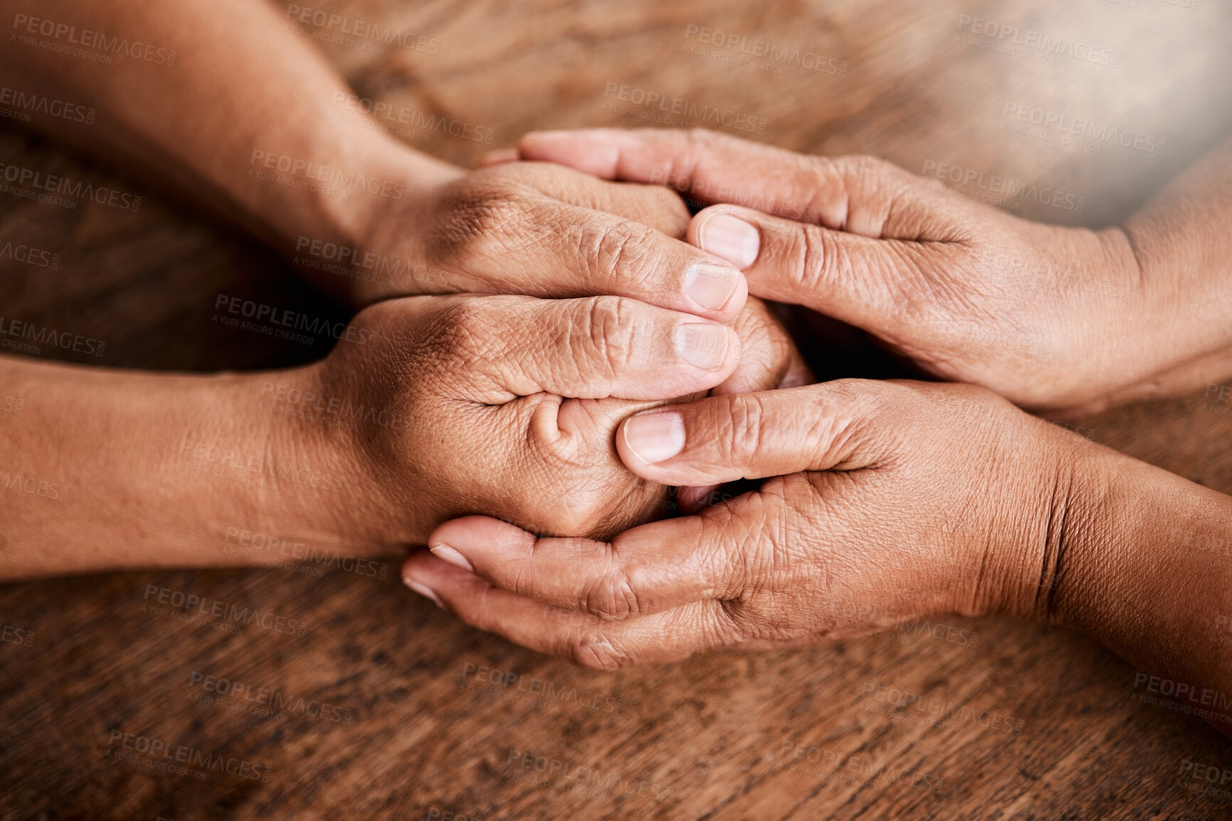 Buy stock photo Shot of an unrecognizable senior couple holding hands and comforting one another at home