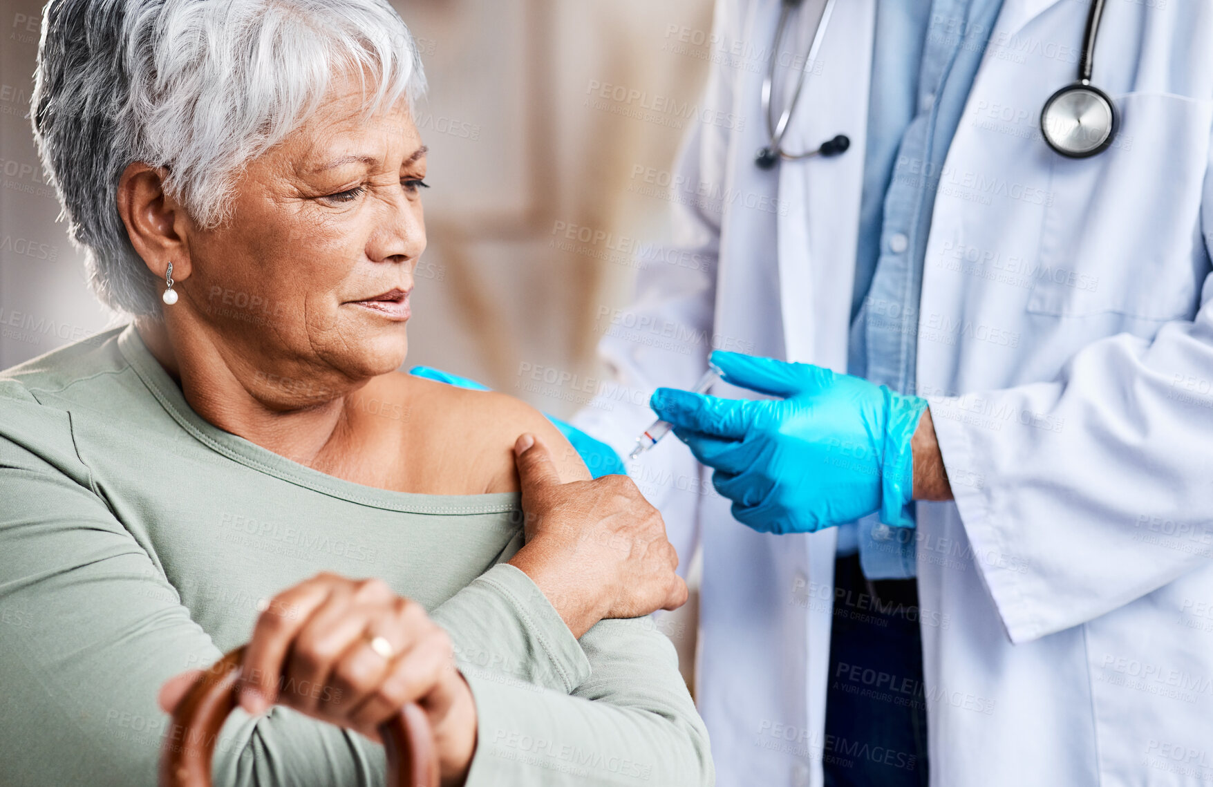 Buy stock photo Shot of a doctor giving an older woman an injection at home