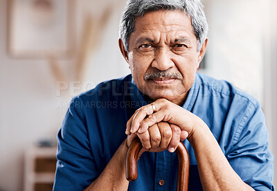 Buy stock photo Shot of a senior man leaning in his walking stick at home