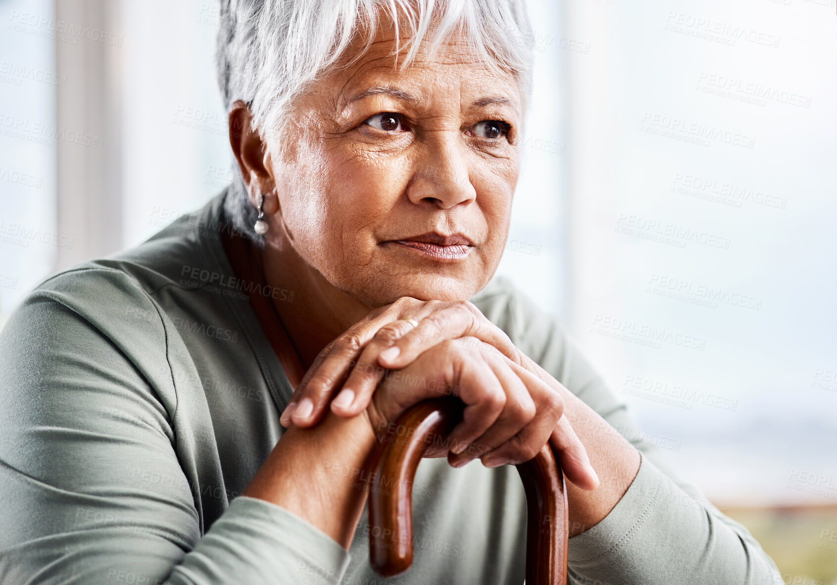 Buy stock photo Shot of a senior woman leaning in her walking stick at home