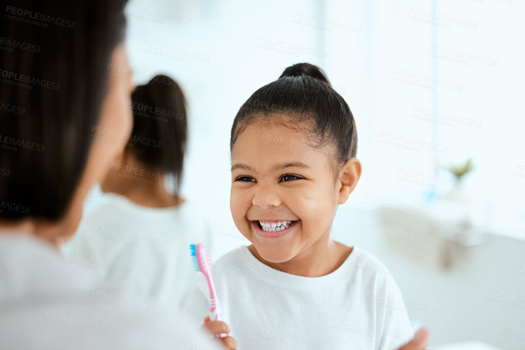 Buy stock photo Shot of an adorable little girl  brushing her teeth while her mother helps her at home