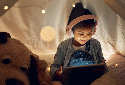 Buy stock photo Girl, child and relax with tablet in tent at night with headphones for watching cartoon movies and videos. Female kid, happy and home with internet for entertainment, online games and education.